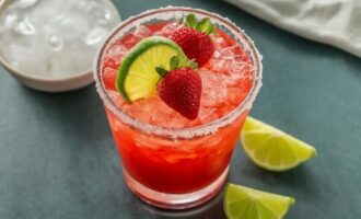 A vibrant strawberry margarita cocktail in a glass with a salted rim